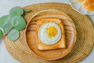 Tahta tabakta kızarmış yumurta ve kızarmış ekmek.