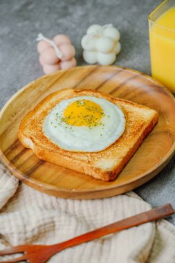 Tahta tabakta kızarmış yumurta ve kızarmış ekmek.