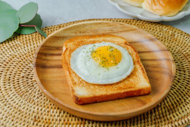 Tahta tabakta kızarmış yumurta ve kızarmış ekmek.