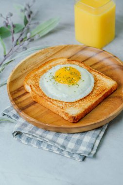 Tahta tabakta kızarmış yumurta ve kızarmış ekmek.