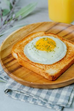 Tahta tabakta kızarmış yumurta ve kızarmış ekmek.