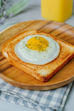 Tahta tabakta kızarmış yumurta ve kızarmış ekmek.