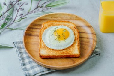 Tahta tabakta kızarmış yumurta ve kızarmış ekmek.