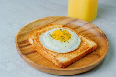 Tahta tabakta kızarmış yumurta ve kızarmış ekmek.