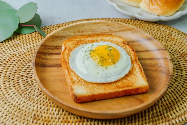 Tahta tabakta kızarmış yumurta ve kızarmış ekmek.