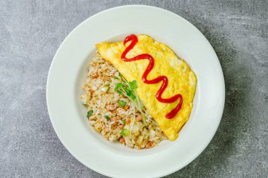 Beyaz tabakta servis edilen omlet pilavı.