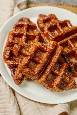 Beyaz tabakta servis edilen çıtır çıtır ve lezzetli waffle yemekleri.
