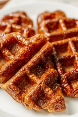 Beyaz tabakta servis edilen çıtır çıtır ve lezzetli waffle yemekleri.