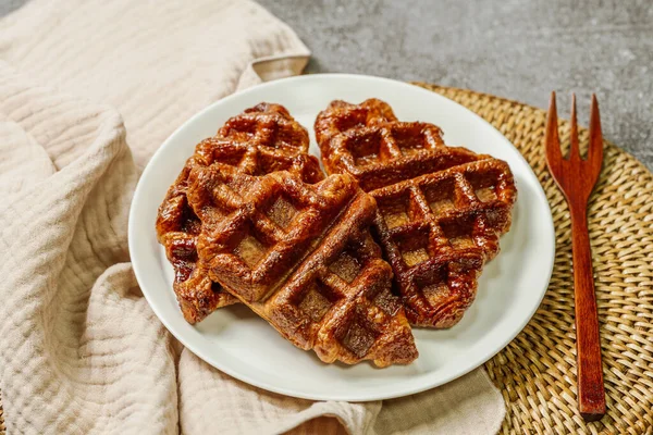 Beyaz tabakta servis edilen çıtır çıtır ve lezzetli waffle yemekleri.