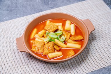 Tteokbokki, Stir-fried Rice Cake : Sliced rice cake bar (garaetteok) or thin rice cake sticks (Tteokbokkitteok) stir-fried in a spicy gochujang sauce with vegetables and fish cakes. clipart