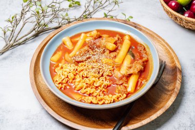 Bu, ramen erişteli tteokbokki. Tteokbokki, gochujang (kırmızı biber ezmesi) sosunda birlikte kızartılmış pirinç keki, sebze ve balık kekinden yapılan baharatlı bir yemektir. Çocuklar ve kadınlar tarafından tercih edilen popüler bir atıştırmalık..