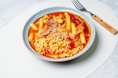Bu, ramen erişteli tteokbokki. Tteokbokki, gochujang (kırmızı biber ezmesi) sosunda birlikte kızartılmış pirinç keki, sebze ve balık kekinden yapılan baharatlı bir yemektir. Çocuklar ve kadınlar tarafından tercih edilen popüler bir atıştırmalık..