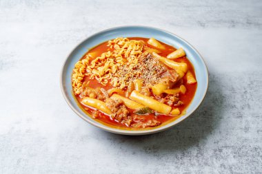 Bu, ramen erişteli tteokbokki. Tteokbokki, gochujang (kırmızı biber ezmesi) sosunda birlikte kızartılmış pirinç keki, sebze ve balık kekinden yapılan baharatlı bir yemektir. Çocuklar ve kadınlar tarafından tercih edilen popüler bir atıştırmalık..