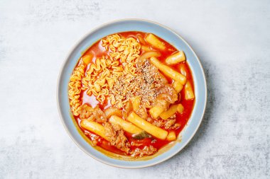 Bu, ramen erişteli tteokbokki. Tteokbokki, gochujang (kırmızı biber ezmesi) sosunda birlikte kızartılmış pirinç keki, sebze ve balık kekinden yapılan baharatlı bir yemektir. Çocuklar ve kadınlar tarafından tercih edilen popüler bir atıştırmalık..
