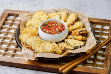 Kızarmış patlıcan, patlıcanı düzleştir ve tempura ununu tara, fazlalıklardan kurtul. Tempura hamuru yapmak için Tempura unu, yumurtayı ve suyu karıştır. Yağ ısınınca hamurdaki kesilmiş patlıcanı kapla ve çıtır çıtır olana kadar kızart. Zekice hizmet et.