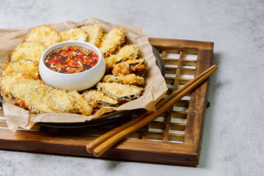 Kızarmış patlıcan, patlıcanı düzleştir ve tempura ununu tara, fazlalıklardan kurtul. Tempura hamuru yapmak için Tempura unu, yumurtayı ve suyu karıştır. Yağ ısınınca hamurdaki kesilmiş patlıcanı kapla ve çıtır çıtır olana kadar kızart. Zekice hizmet et.