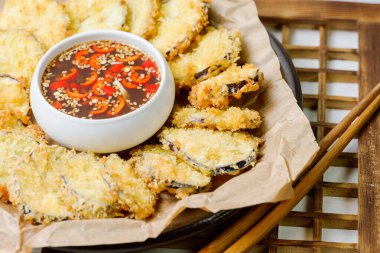 Kızarmış patlıcan, patlıcanı düzleştir ve tempura ununu tara, fazlalıklardan kurtul. Tempura hamuru yapmak için Tempura unu, yumurtayı ve suyu karıştır. Yağ ısınınca hamurdaki kesilmiş patlıcanı kapla ve çıtır çıtır olana kadar kızart. Zekice hizmet et.