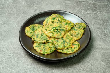 Buchujeon, Kore Chive Pancake 'i bu yemeği hazırlamak için, soğan, jülyen havuç ve yeşil biber unla karıştırılır ve tavada kızartılır, yuvarlak, krep şeklinde. Krep daha sonra sirke bazlı soya sosuyla servis edilir..