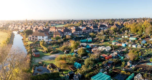An aerial view of local council run allotment plots on the edge of a picturesque town
