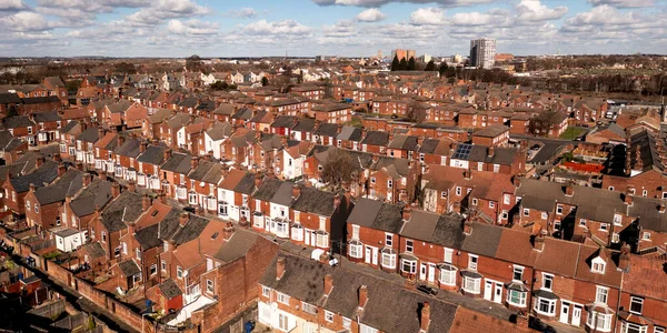 An aerial panorama view of rows of red brick back to back terraced housing in a run down Northern city in England