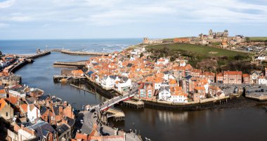 Whitby, İngiltere - 12 Mart 2023. Kuzey Yorkshire 'daki Whitby limanı ve sahil kasabasının hava manzarası Whitby Abbey' nin önde gelen