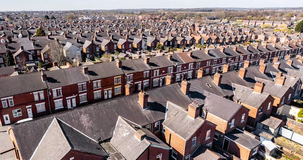 An aerial view above the rooftops of run down back to back terraced houses in the North of England