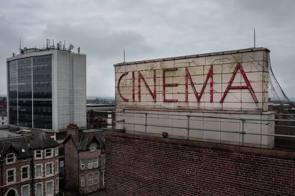 A Cinema sign on the roof of a movie theatre in a retro or art deco style