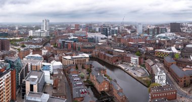 Leeds, İngiltere - 2 Mayıs 2023. Brewery Wharf 'ın deniz kenarındaki apartmanlarından geçen nehir havası ile Leeds şehir manzarası gökyüzü manzarası.