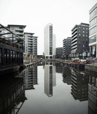 Leeds Dock, Leeds, İngiltere 2 Mayıs 2023. Leeds Rıhtımı manzarası, eski adıyla Clarence Rıhtımı modern mimarisi ve nehir kenarındaki özel apartman blokları River Aire 'e yansıyor.