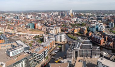 Leeds şehir merkezinin modern mimarisi ve Leeds Rıhtımı 'ndaki özel nehir kenarındaki apartman bloklarıyla hava panoramik görüntüsü.