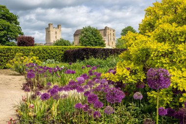 HELMSLEY Şatosu, Kuzey Yorkshire, İngiltere - 29 Mayıs 2023. Helmsley Kalesi 'nin eski mimarisinin Helmsley Duvarlı Bahçeleri' nin resmi ve renkli çiçek yataklarından bir görüntüsü.