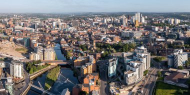 Leeds, İngiltere - 3 Mayıs 2023. Leeds şehir manzarasının modern mimarisi ve Leeds Rıhtımı 'ndaki özel nehir kenarındaki apartman blokları ile hava panoramik görüntüsü.