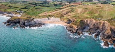 Günbatımında Cornwall 'daki Gunwalloe' de tarihi kilisesi ve Dolar Koyu ile kilise manzarası.