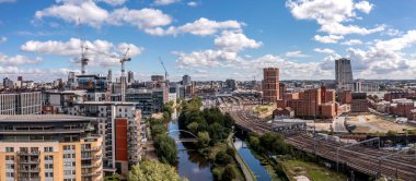Leeds, İngiltere - 15 Ağustos 2023. Yorkshire şehrinin tren istasyonu ve Granary Wharf bölgesiyle Leeds şehir merkezinin panoramik bir görüntüsü.
