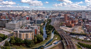 Leeds, İngiltere - 15 Ağustos 2023. Yorkshire şehrinin tren istasyonu ve Granary Wharf bölgesiyle Leeds şehir merkezinin panoramik bir görüntüsü.