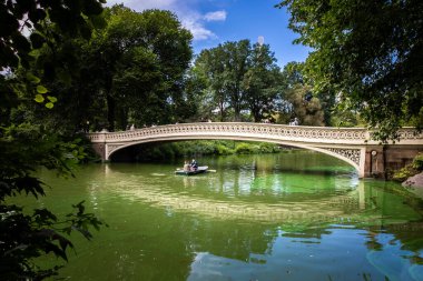 CENTRAL PARK, New York, ABD, Eylül, 15, 2023. Turistler ve tatilciler New York 'taki ünlü Bow Köprüsü' nün altındaki Central Park Gölü 'nde bir kayık kiraladı.