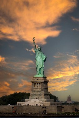 LIBERTY, New York, ABD - 16 EYLÜL 2023. Çarpıcı bir günbatımı gökyüzü ve kopyalama alanı olan Özgürlük Heykeli 'nin dikey bir kara sapı.