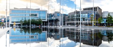 CENENENENENENARY Squarare, BIRMINGHAM, İngiltere - 5 Ekim 2023. Birmingham 'ın yeni Senfoni Salonu ve Rep tiyatrosunun panoramik manzarası şehir merkezindeki Centenary Meydanı' ndaki çeşmeye yansıdı.