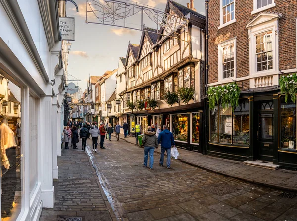 StONEGATE, YORK, UK - 17 Kasım 2023. Alışveriş yapanlar ve kalabalık Stonegate alışveriş caddesinde perakende satış mağazalarıyla yürüyorlar. Gün batımında York 'taki Kathe Wohlfahrt Noel mağazası da dahil.