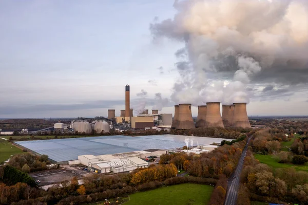 A large coal fired power plant with poisonous gas cloud and carbon dioxide emissions polluting the air in an environmental damage concept with copy space