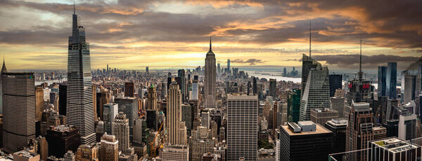 MIDTOWN MANHATTAN, NEW YORK, USA, - SEPTEMBER 15, 2023.  An aerial panoramic view of the Empire State building and surrounding district in Midtown Manhattan from the Top of the Rock at sunrise