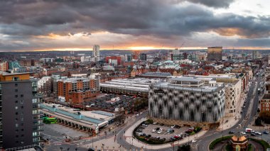 LEEDS, İngiltere - 12 Şubat 2024. Batı Yorkshire 'daki Leeds şehir merkezinin panoramik bir görüntüsü otobüs durağı ve perakende satış mağazası ve gün doğumunda dramatik bir gökyüzü.