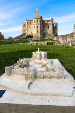 WARKWORTH CASTLE, NORTHUMBERLAND, UK - MARCH 16, 2024. A vertical view of Warkworth Castle Keep in Northumberland with a to scale model in the grounds clipart