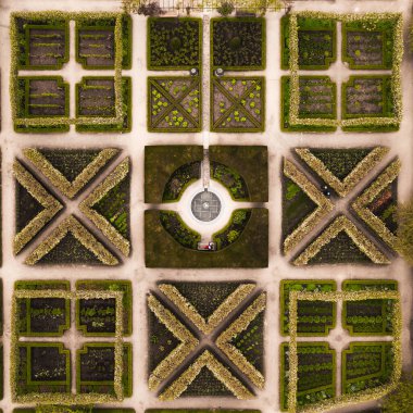 Su özellikleri olan İngiliz resmi bahçesindeki peyzajlı çiçek yataklarının hemen üstündeki hava manzarası.