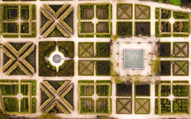 Su özellikleri olan İngiliz resmi bahçesindeki peyzajlı çiçek yataklarının hemen üstündeki hava manzarası.