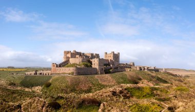 BAMBURGH Şatosu, NORTHUMBERLAND, İngiltere - 23 Nisan 2024. Bamburgh kalesinin hava manzarası ve güzel Northumberland sahilindeki kum tepeleri.