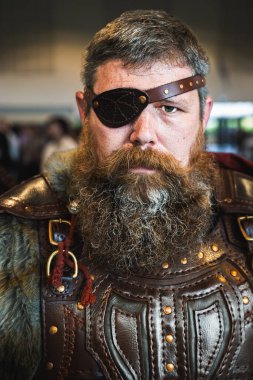 Head and shoulders portrait of a tough and strong male cosplayer dressed as a Viking with realistic leather clothing and fur clipart