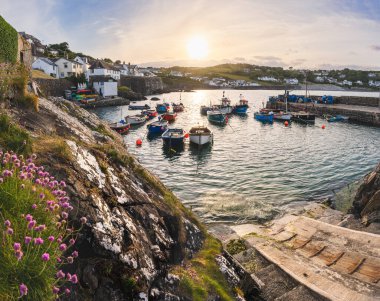 CORNWALL, UK 9 HAZİRAN 2024. Günbatımında Cornwall 'daki Coverack isimli tuhaf balıkçı köyünün gelgit limanına demirlemiş geleneksel Cornish balıkçı teknelerinin panoramik manzarası