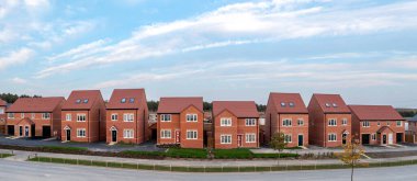 A panoramic landscape row of new build detached homes on a construction site for the UK Government's Right To Buy scheme during a new house shortage with sold sign clipart