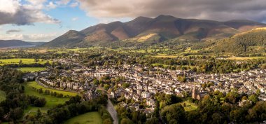 Aerial panoramic landscape of the Lake District town of Keswick on a beautiful Summer day with Bassenthwaite Lake and Skiddaw in The Northern Fells behind clipart